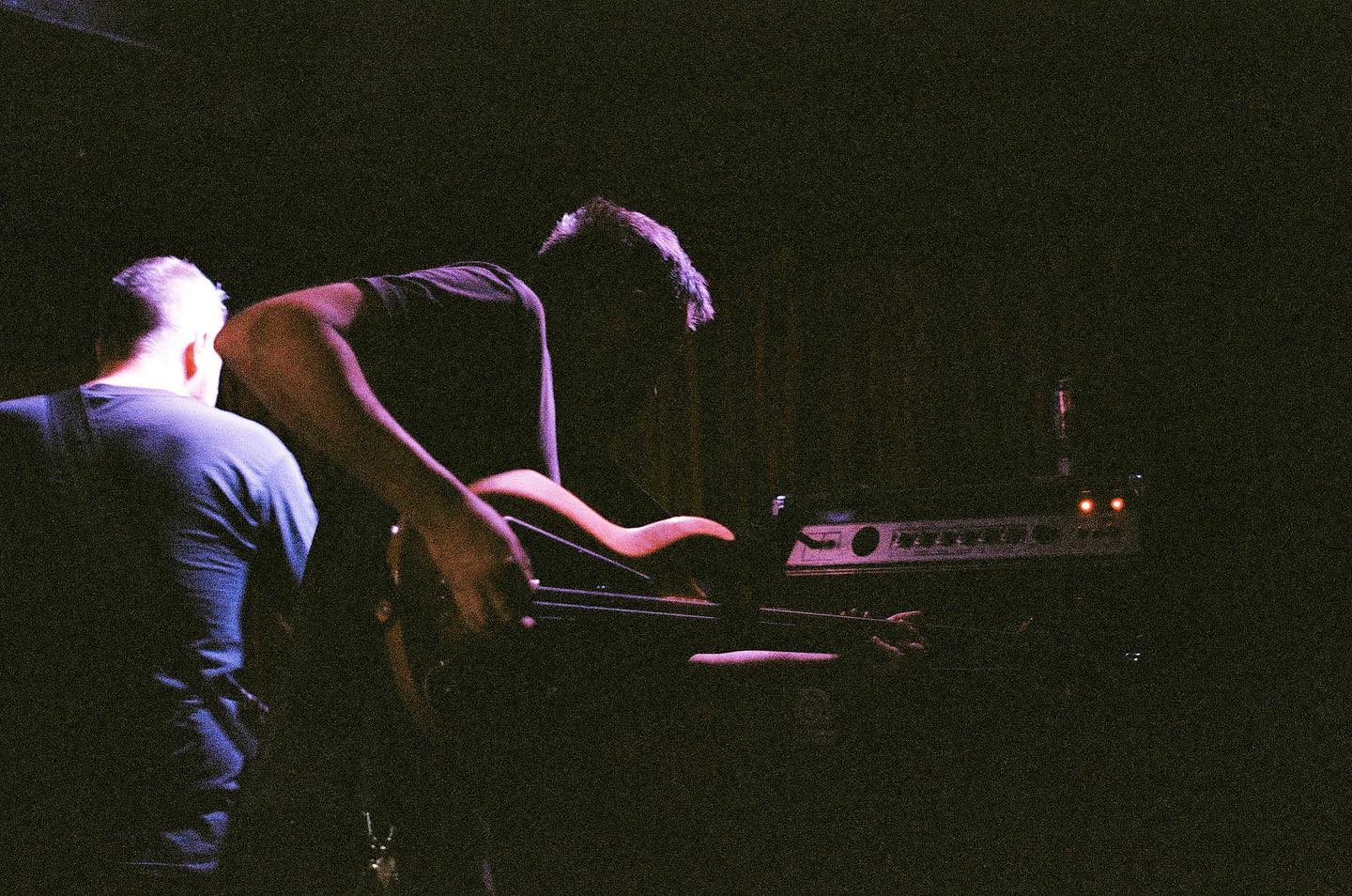 a band on stage in a darkened room